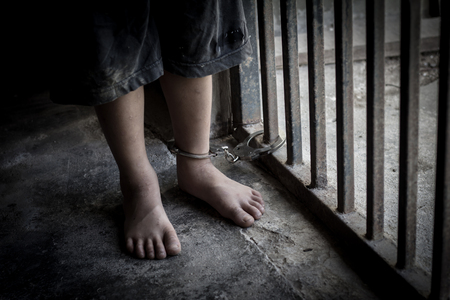 The child is trapped in an iron cage and locked with a shackle,Victims of human trafficking,Violence against children, International Anti-Trafficking Dayの写真素材