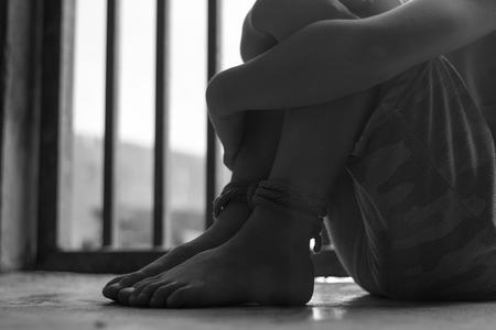 The boy was tied to his feet with a rope, Victims of human trafficking,Violence against children, International Anti-Trafficking Dayの写真素材