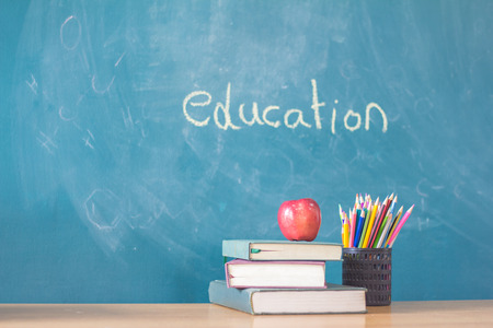 Apple puts on a book studying ,The background is blackboard, educational conceptsの写真素材