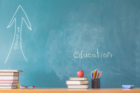 Composition of stationery ,books and an red apple on the desk,The background is blackboard, educational conceptsの写真素材