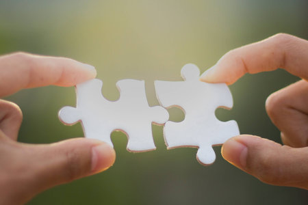 Two human hands connected jigsaw puzzle white, Joint Business Concepts.