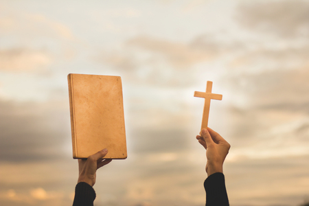 Human Hand Holds Cross and Bible, Worship, sins and prayer, Religious concept.の写真素材