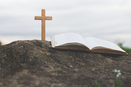 The cross and the bible is on the rock.Worship, sins and prayer.の写真素材