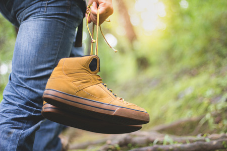 Feet in shoes on a forest path,Hikers boots on forest trail.の写真素材