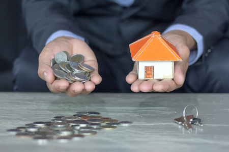 House models and coin in human hands, Mortgage concept by money house from the coins.の写真素材