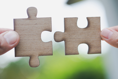 Two human hands connected jigsaw puzzle white, Joint Business Concepts.