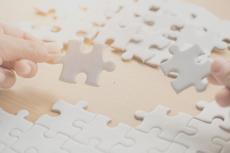 Close up of hands business women connecting jigsaw puzzleon, Teamwork workplace success and strategy concept.の写真素材