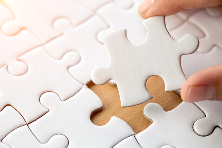 Hand put the last piece of jigsaw puzzle to complete the mission, Business solutions, success and strategy conceptの写真素材