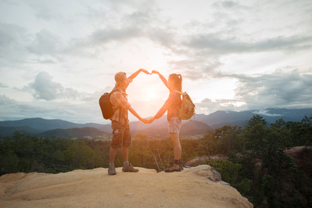 Couple Man and Woman sitting on cliff enjoying mountains, Travel happy emotions Lifestyle concept.の写真素材