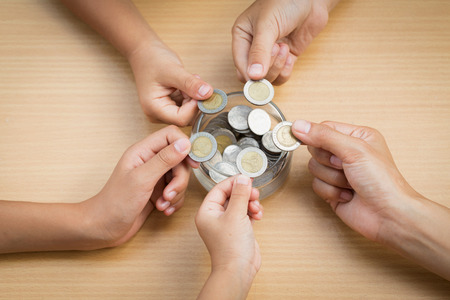 Many children holding coins putting in glass. concept saving money for financeの写真素材