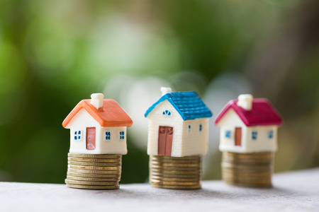 House model on coins stacks with calculator as background. Concept for property ladder, mortgage and real estate investment.の写真素材