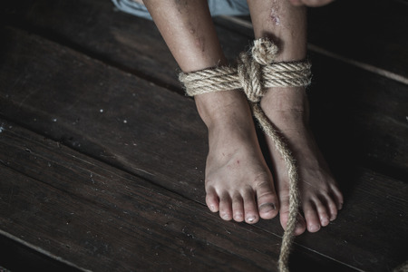 Stop violence Against Children, foot tied up with rope in emotional stress, The concept of stopping violence against children. Human rights Day concept. Anti-trafficking concept.の写真素材