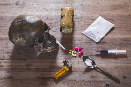 Drugs of various kinds and human skulls on the wooden table, Collection of different hard drugs...