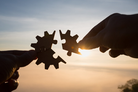 Silhouette Woman hands connecting couple puzzle piece against sunrise, Last Jigsaw Puzzle, Business solutions, target, success, goals and strategy conceptsの写真素材