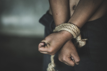 Hands tied up with rope of a missing kidnapped, abused, Violence against children, victim child in pain, human trafficking Concept.の写真素材