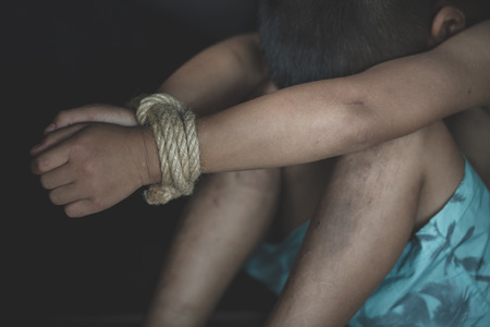 Hands tied up with rope of a missing kidnapped, abused, Violence against children, victim child in pain, human trafficking Concept.の写真素材