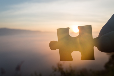 Silhouette Woman hands connecting couple puzzle piece against sunrise, Business solutions, target, success, goals and strategy conceptsの写真素材