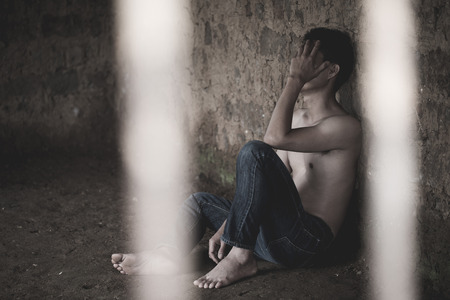 Male prisoners were severely strained in the dark prison, violence, human trafficking,  prison and prisoner concept.の写真素材