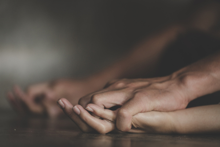 Close up of man hands holding a woman hands for  abuse concept.の写真素材