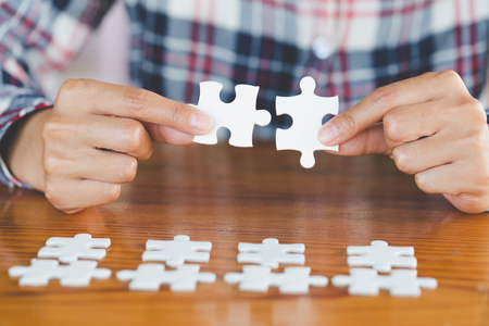 Close up of hands business women connecting jigsaw puzzleon, Teamwork workplace success and strategy concept.の写真素材