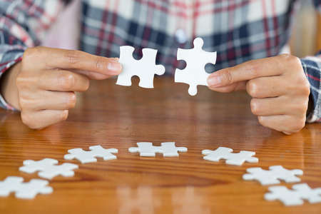 Close up of hands business women connecting jigsaw puzzleon, Business Success,  Teamwork workplace success and strategy concept.の写真素材