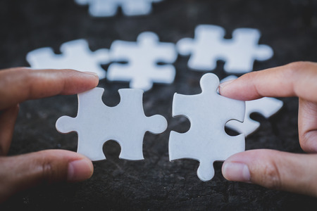 Close up of hands business women connecting jigsaw puzzleon, Teamwork workplace success and strategy concept.の写真素材