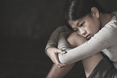 The girl sat depressed in a dark room, Violence against children, Domestic violence, Stop Sexual abuse And human trafficking  Concept, stop violence against Women, international women's dayの写真素材