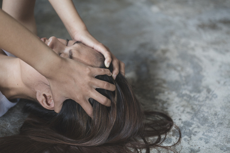 Woman lying on the floor crying with depression, Depressed woman sitting on ground, family problems, kitchen, abuse, Domestic violence, The concept of depression and suicide.の写真素材