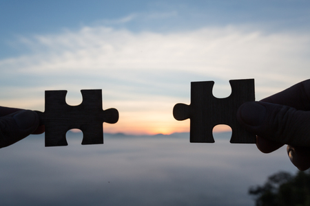 Silhouette Woman hands connecting couple puzzle piece against sunrise, Business solutions, target, success, goals and strategy conceptsの写真素材