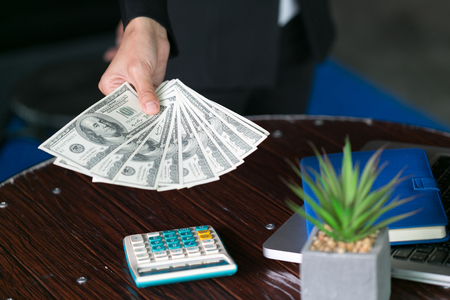 Business man displaying a spread of cash over,  spending money or profit from business operations conceptの写真素材