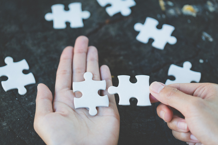 Close up of hands business women connecting jigsaw puzzleon, Business Success,  Teamwork workplace success and strategy concept.の写真素材