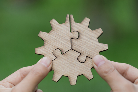 Closeup hand of man connecting jigsaw puzzle with sunlight effect, Business solutions, success and strategy conceptの写真素材