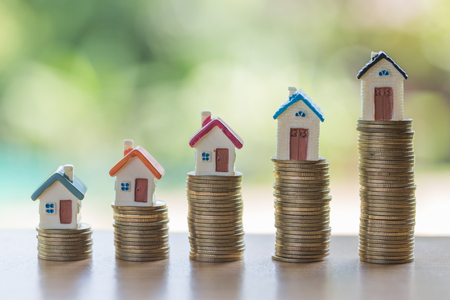 Mini house on stack of coins,Money and house,  Mortgage, Savings money for buy house and loan to business investment for real estate concept. Invesment and Risk Management.の写真素材