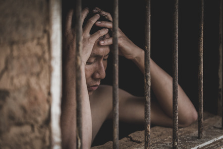 Male prisoners were severely strained in the dark prison, Imprisonment, violence, human trafficking,  prison and prisoner concept.の写真素材