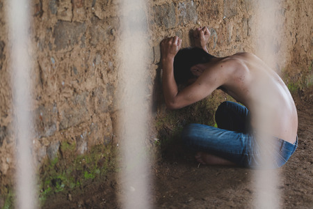 Male prisoners were severely strained in the dark prison, violence, human trafficking,  prison and prisoner concept.の写真素材
