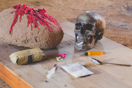 Drugs of various kinds and human skulls on the wooden table, Collection of different hard drugs Heroin, Pills, Tobacco,The concept of death from drugsの写真素材