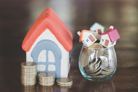 Mini house on stack of coins,Money and house,  Mortgage, Savings money for buy house and loan to business investment for real estate concept. Invesment and Risk Management.の写真素材