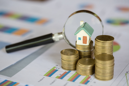 Stack coin and bar graph with grow,  magnifying glass searching for a new home, Loan for real estate or save money for buy a house to family in the future concept.の写真素材