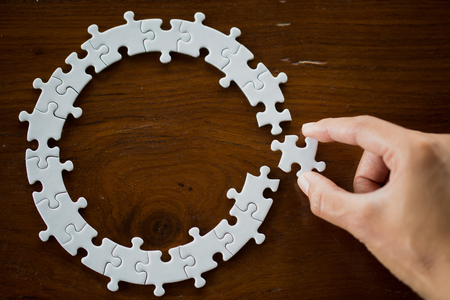 Hand put the last piece of jigsaw puzzle to complete the mission, Business solutions, success and strategy conceptの写真素材