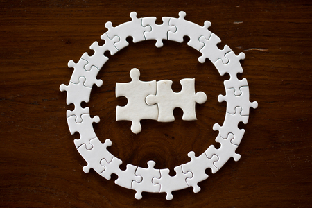 White jigsaw  on wooden table, closeup. creative idea, business concept,の写真素材