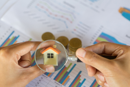 Hand hold a magnifying glass searching for a new home, Loan for real estate or save money for buy a house to family in the future concept.の写真素材