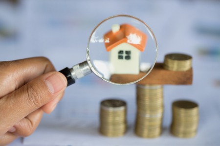 Hand hold a magnifying glass searching for a  home, Loan for real estate or save money for buy a house to family in the future concept, Risk management.の写真素材