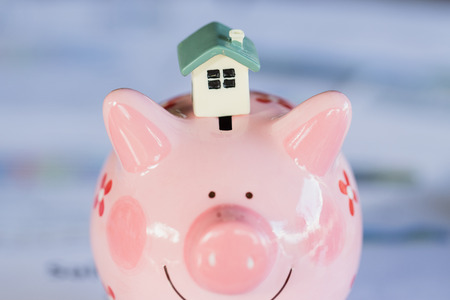 A house model placed on a piggy bank, finance and banking,  Saving money and property Management concept.の写真素材