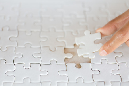 Hand put the last piece of jigsaw puzzle to complete the mission, Business solutions, success and strategy conceptの写真素材