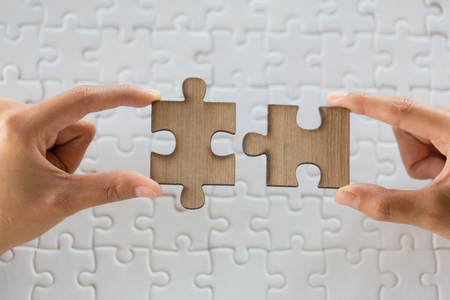 Close up of hands business women connecting jigsaw puzzleon, Teamwork workplace success and strategy concept.の写真素材