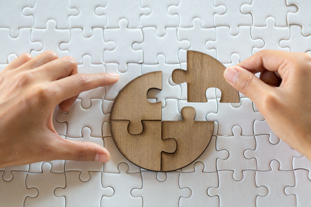 Close up of hands business women connecting jigsaw puzzleon, Teamwork workplace success and strategy concept.の写真素材