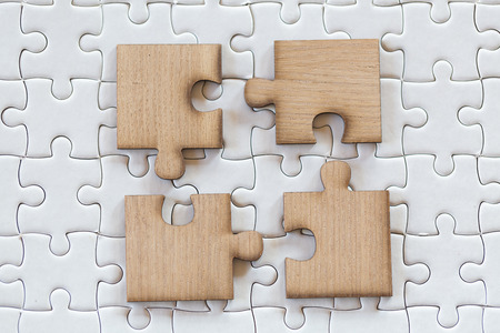 4 Four brown pieces of puzzle on a white jigsaw background, last piece of jigsaw puzzle to complete the mission, Business solutions, success and strategy conceptの写真素材
