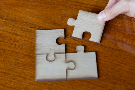 Hand put the last piece of jigsaw puzzle to complete the mission, Business solutions, success and strategy conceptの写真素材