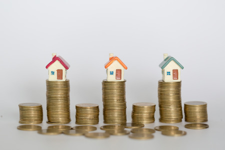 Mini house on stack of coins,Money and house, Real estate investment, Save money with stack coin, Mortgage concept, isolatedの写真素材