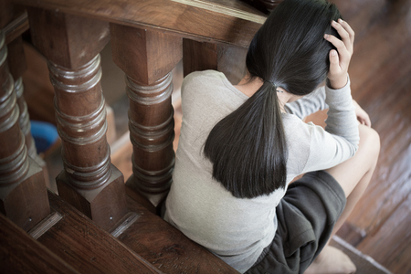 Woman lying on the floor crying with depression, Depressed woman sitting on ground, family problems, kitchen, abuse, Domestic violence, The concept of depression and suicide.の写真素材